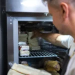 Szakács alapanyagokat pakol a hűtőkamrában