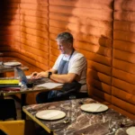 Gáspár Attila laptopon dolgozik egy étterem bokszasztalánál