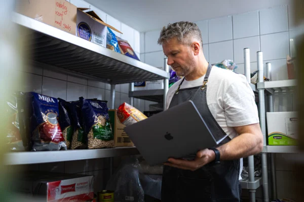 Séf laptoppal ellenőrzi a raktári alapanyagokat